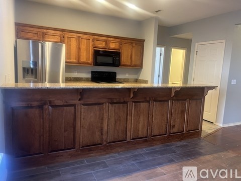A kitchen with wooden cabinets and a stainless steel refrigerator.