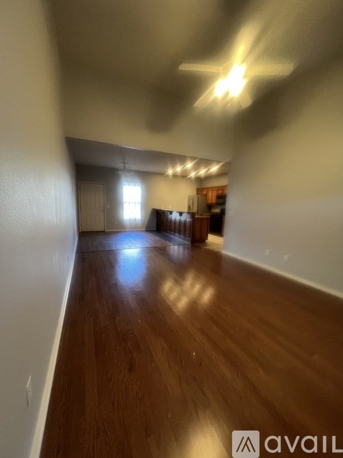 A room with wooden floors and a ceiling fan.