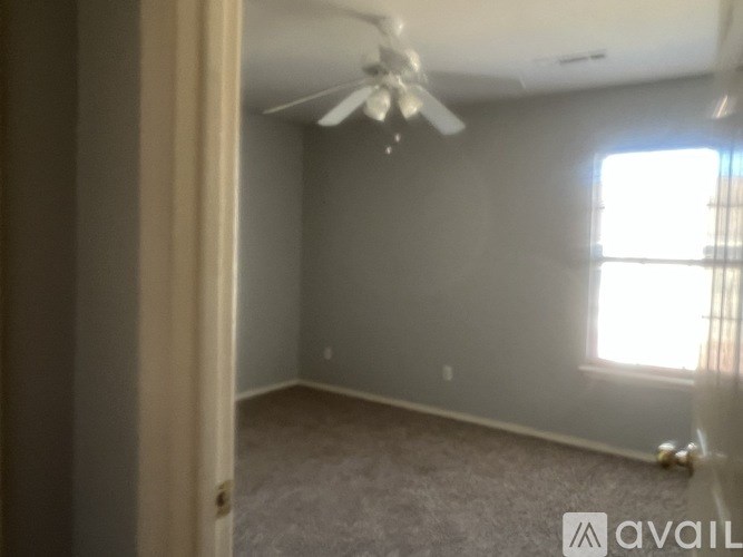 A room with a ceiling fan and a window.