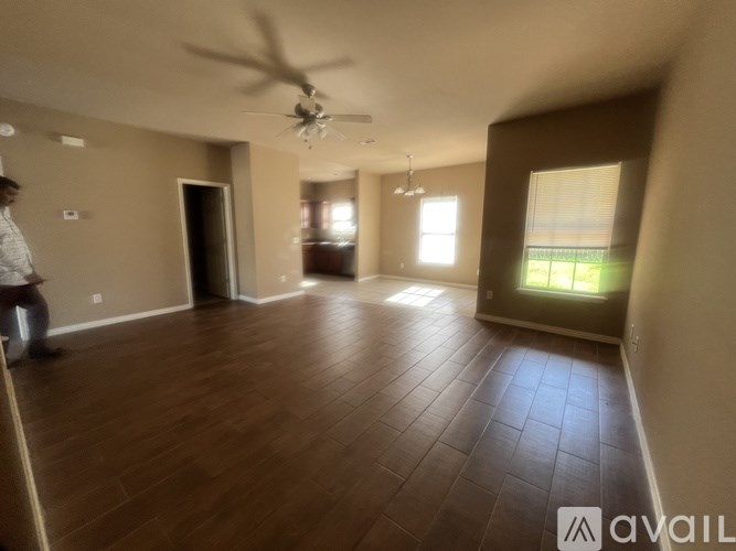 A room with wooden flooring and a ceiling fan.