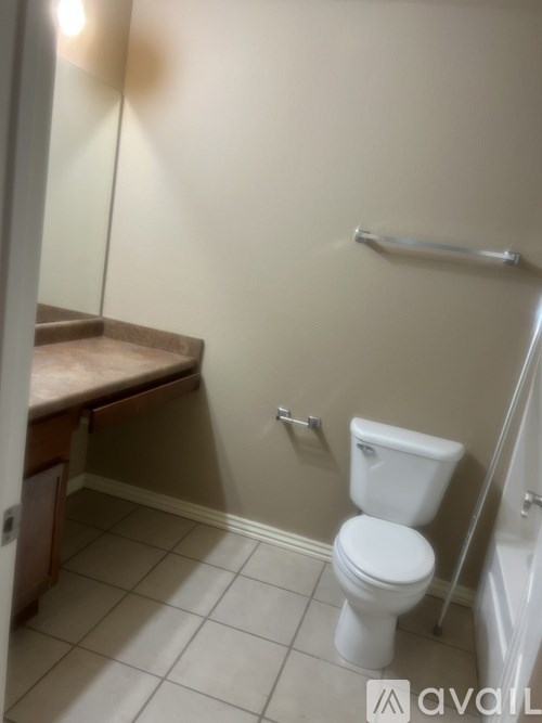 A white toilet in a small bathroom with a white wall and a white door.