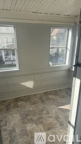 A room with a window and a tiled floor.