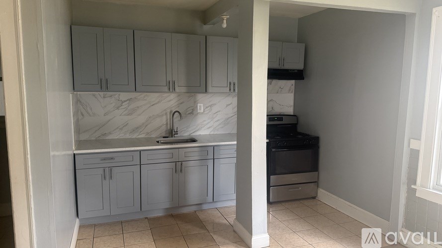 A kitchen with white cabinets and a marble countertop.