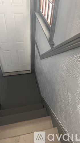 A stairway with a white door and a window.