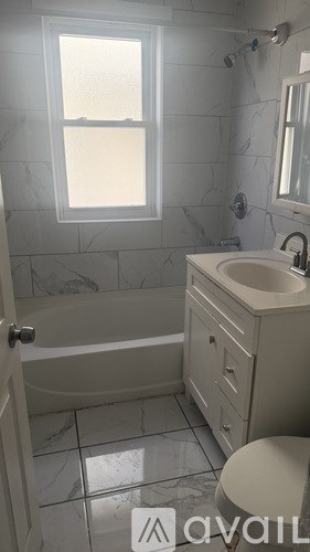 A bathroom with a tub, toilet, and sink.