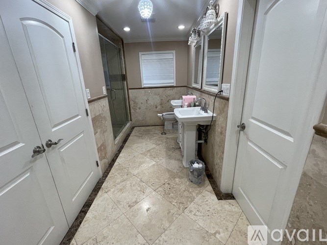 A bathroom with a marble floor and white walls.