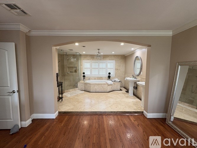 A large, well-lit bathroom with a bathtub, toilet, and sink.