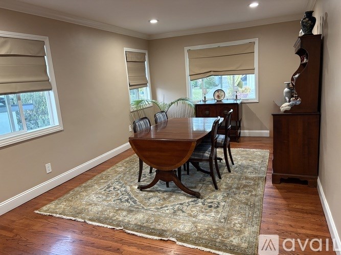 A dining room with a wooden table and chairs.
