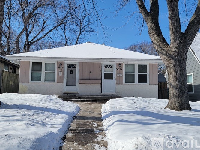 A house with a snow-covered front yard.