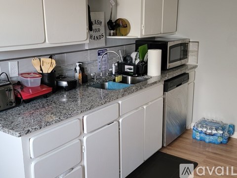 A kitchen with granite countertops and white cabinets.