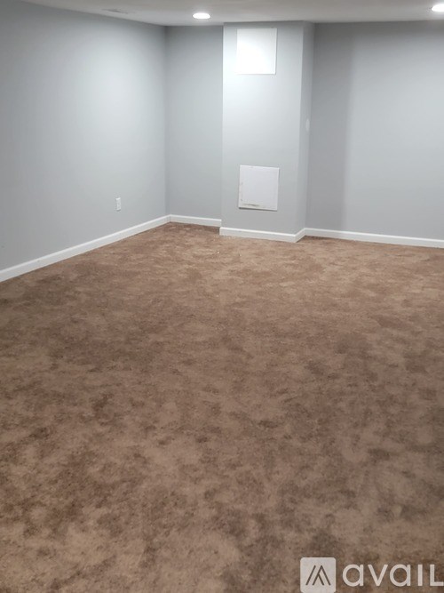 A room with a carpeted floor and a white door.