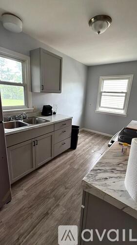 A kitchen with a sink, cabinets, and a window.