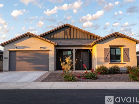 A house with a brown roof and a garage door is available for purchase.