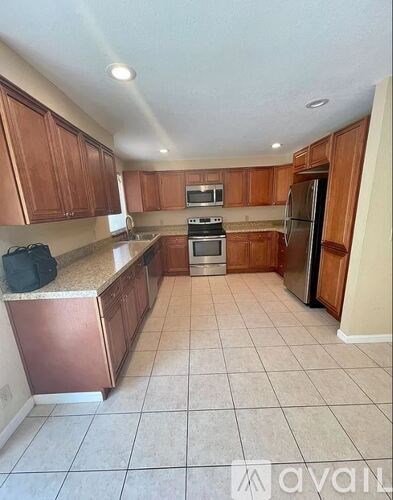 A kitchen with wooden cabinets and a refrigerator.