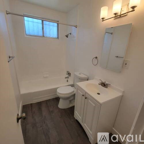 A white bathroom with a toilet, sink, and tub.