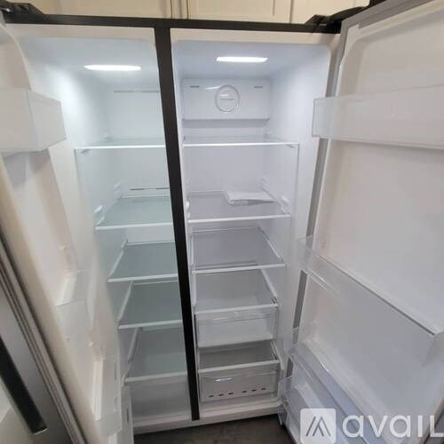 A white refrigerator with the door open and shelves inside.