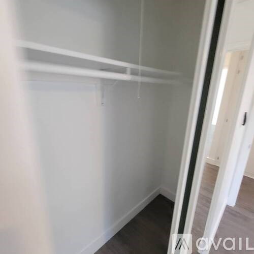A white shelf in a room with a wooden floor.