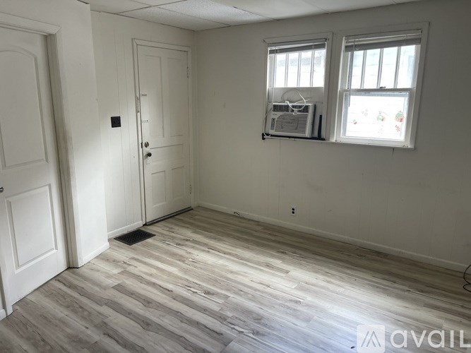 A room with a window and a fan on the wall.
