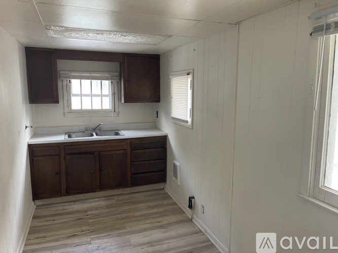 A kitchen with wooden cabinets and a window.