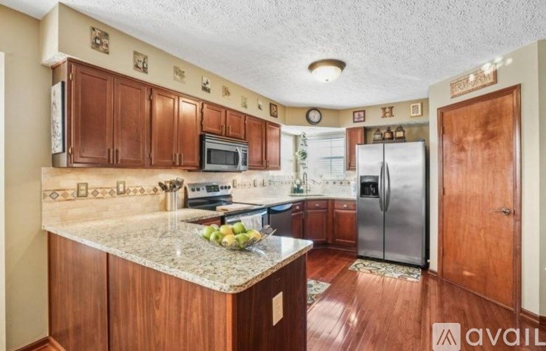A kitchen with wooden cabinets and a granite countertop.