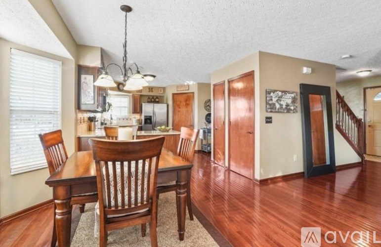 A dining room with a wooden table and chairs.