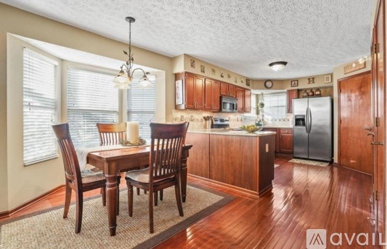 A kitchen with wooden cabinets and a dining table with chairs.