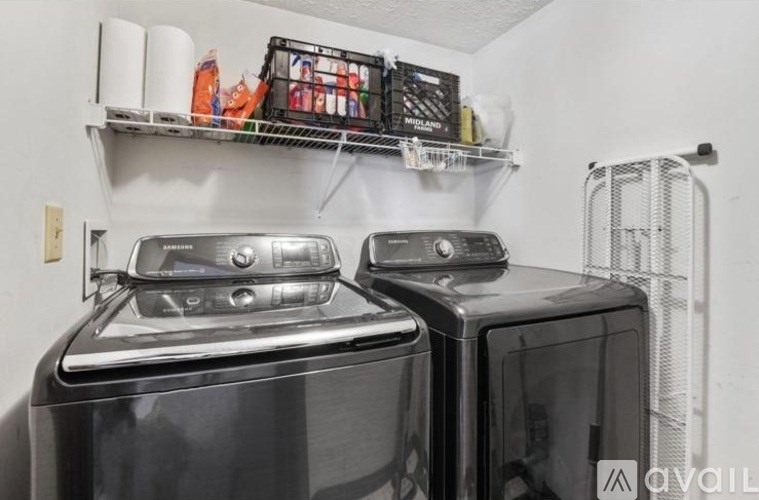 A black microwave is sitting on top of a black oven.