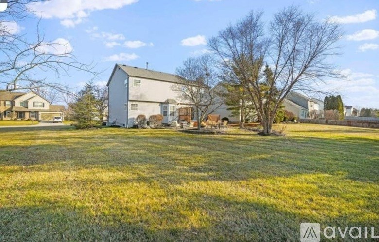 A house with a yard and a tree in front of it.