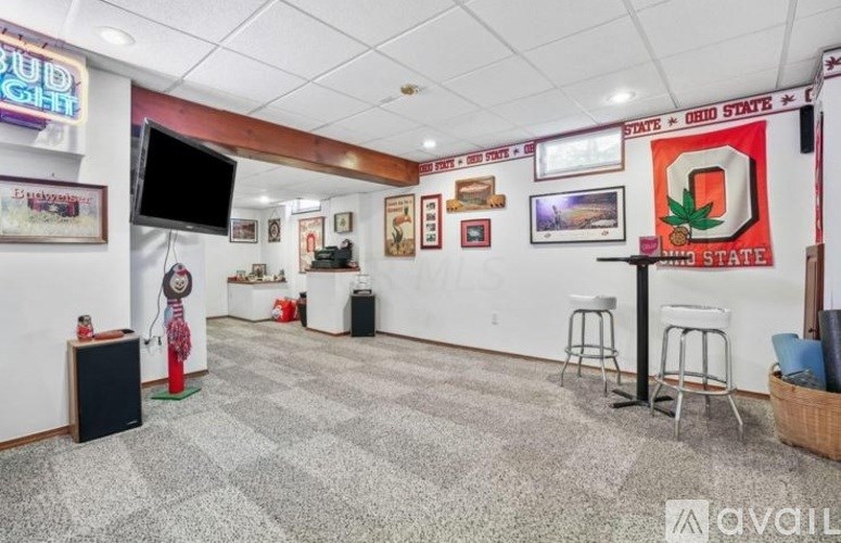 A room with a white wall and a red Ohio State logo on the right side.