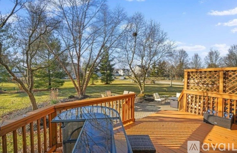 A deck with a table and chairs overlooking a yard.