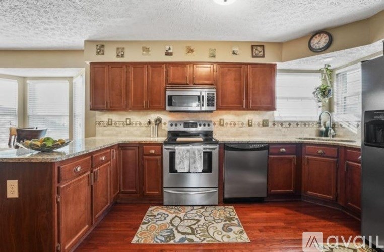 A kitchen with wooden cabinets and a stainless steel dishwasher.