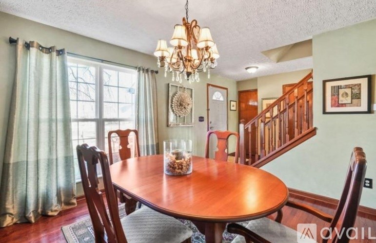 A dining room with a wooden table and chairs.