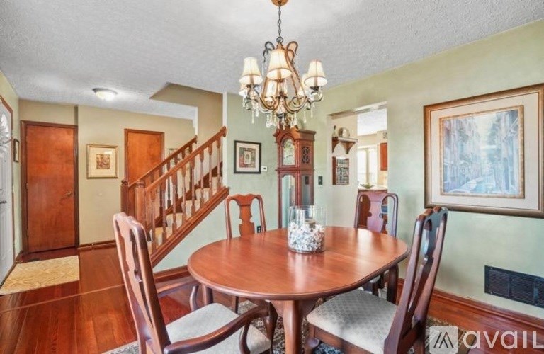 A dining room with a wooden table and chairs.