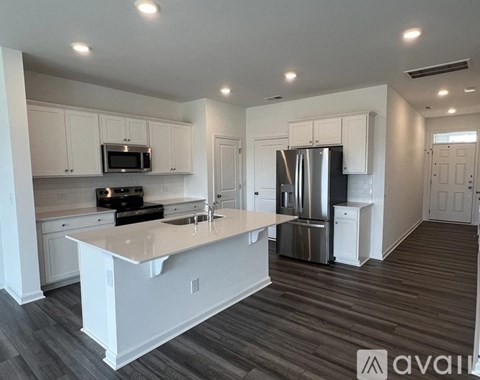 A kitchen with white cabinets and a refrigerator.