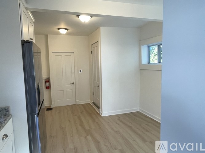 A kitchen with a refrigerator, cabinets, and a countertop.
