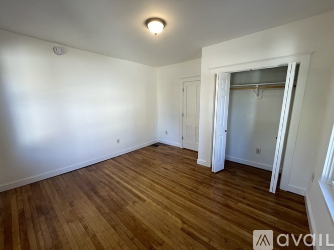 A room with wooden flooring and white walls.