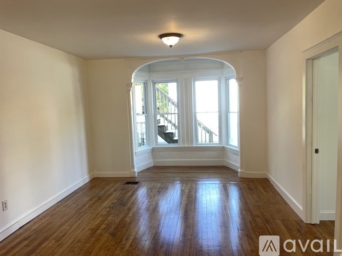 A room with wooden floors and a large window.