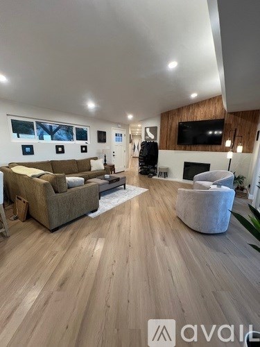 A living room with a brown couch and a white chair.