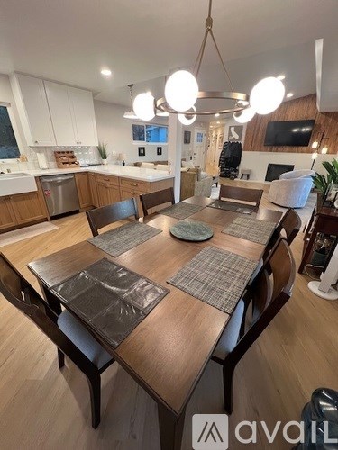 A modern kitchen with a wooden dining table and chairs.