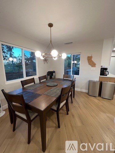 A dining room with a wooden table and chairs.
