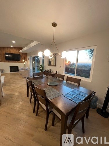 A dining room with a wooden table and chairs.