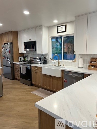 A kitchen with white countertops and wooden cabinets.