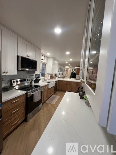 A modern kitchen with wooden cabinets and stainless steel appliances.