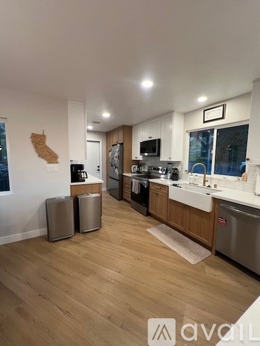 A kitchen with wooden floors and white walls.