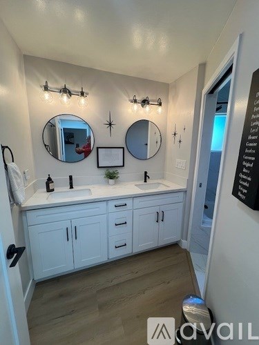 A bathroom with white cabinets and a sink under a mirror.