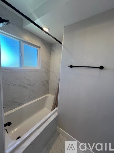 A bathroom with a tub and a window.