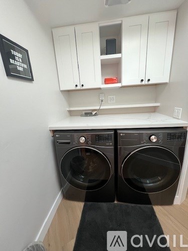A black and white laundry room with two front loading washing machines.