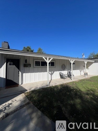 A white house with a porch and a covered patio.