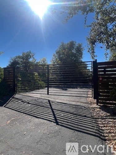 A sunny day with a gate in the foreground.