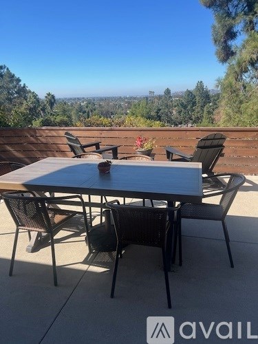 A table and chairs set up on a patio with a view of the trees.